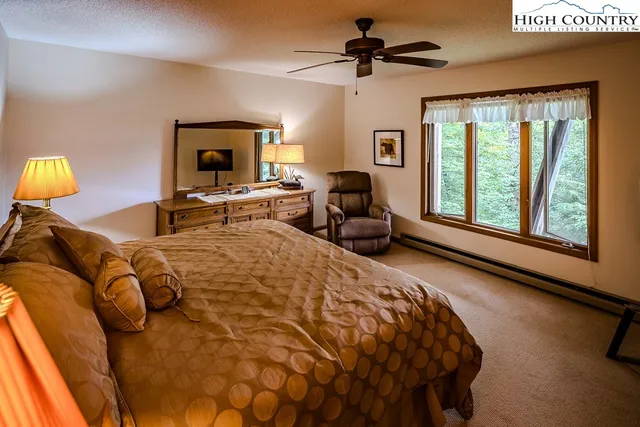 a spacious bedroom with a bed and a flat screen tv