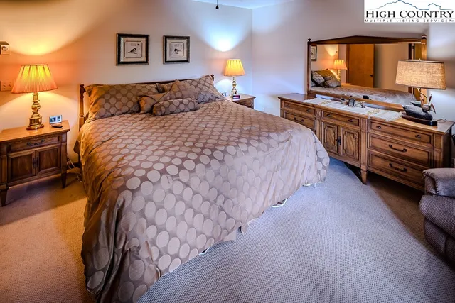 a bedroom with a bed and a flat tv screen on dresser