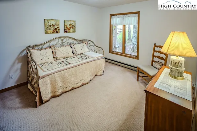 a bed sitting in a bedroom next to a window