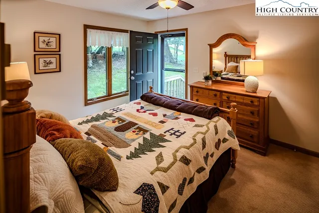 a bedroom with a bed and a dresser next to a window
