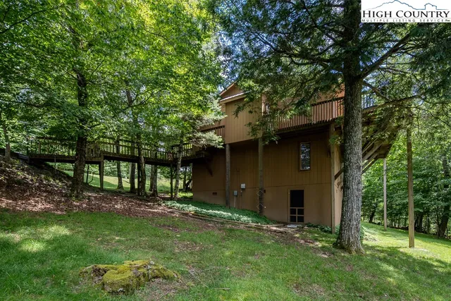 an aerial view of a house with balcony and trees al around