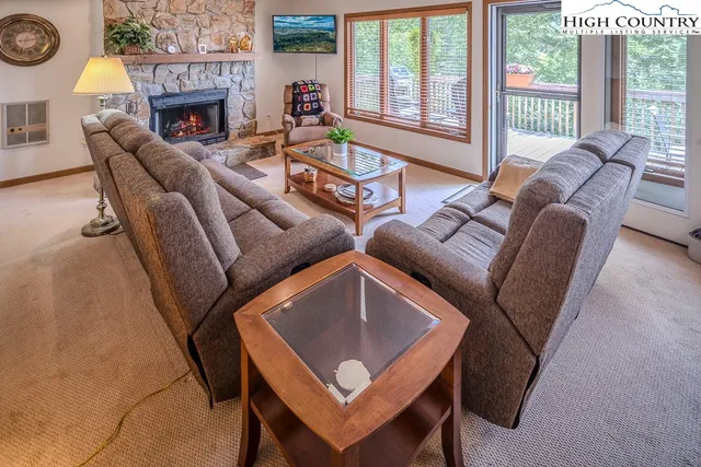 a living room with furniture a fireplace and a floor to ceiling window