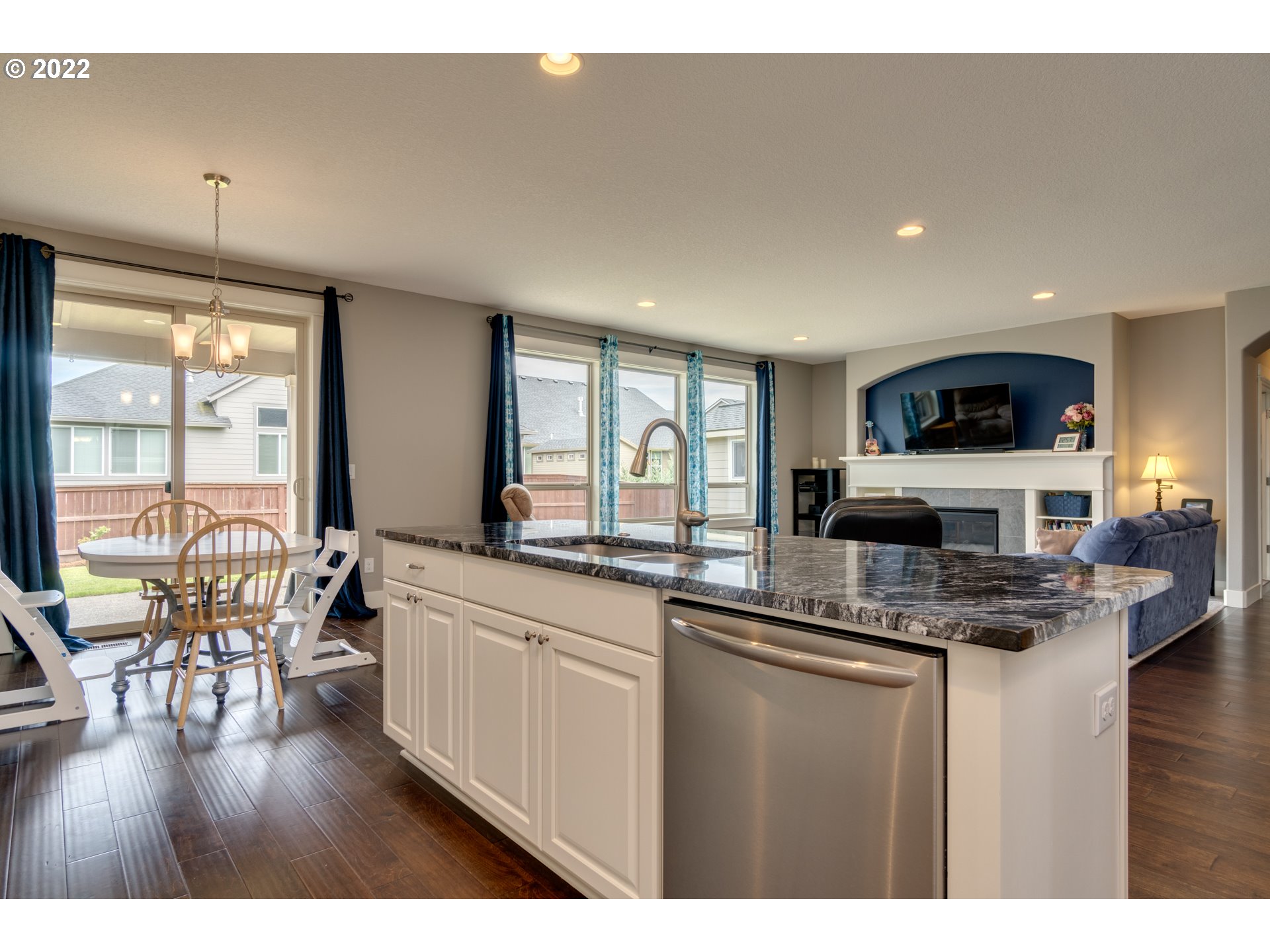 1626 South 46th Place Ridgefield, WA 98642 - Photo 11 of 32 a kitchen with stainless steel appliances granite countertop a stove top oven a sink a dining table and chairs with wooden floor