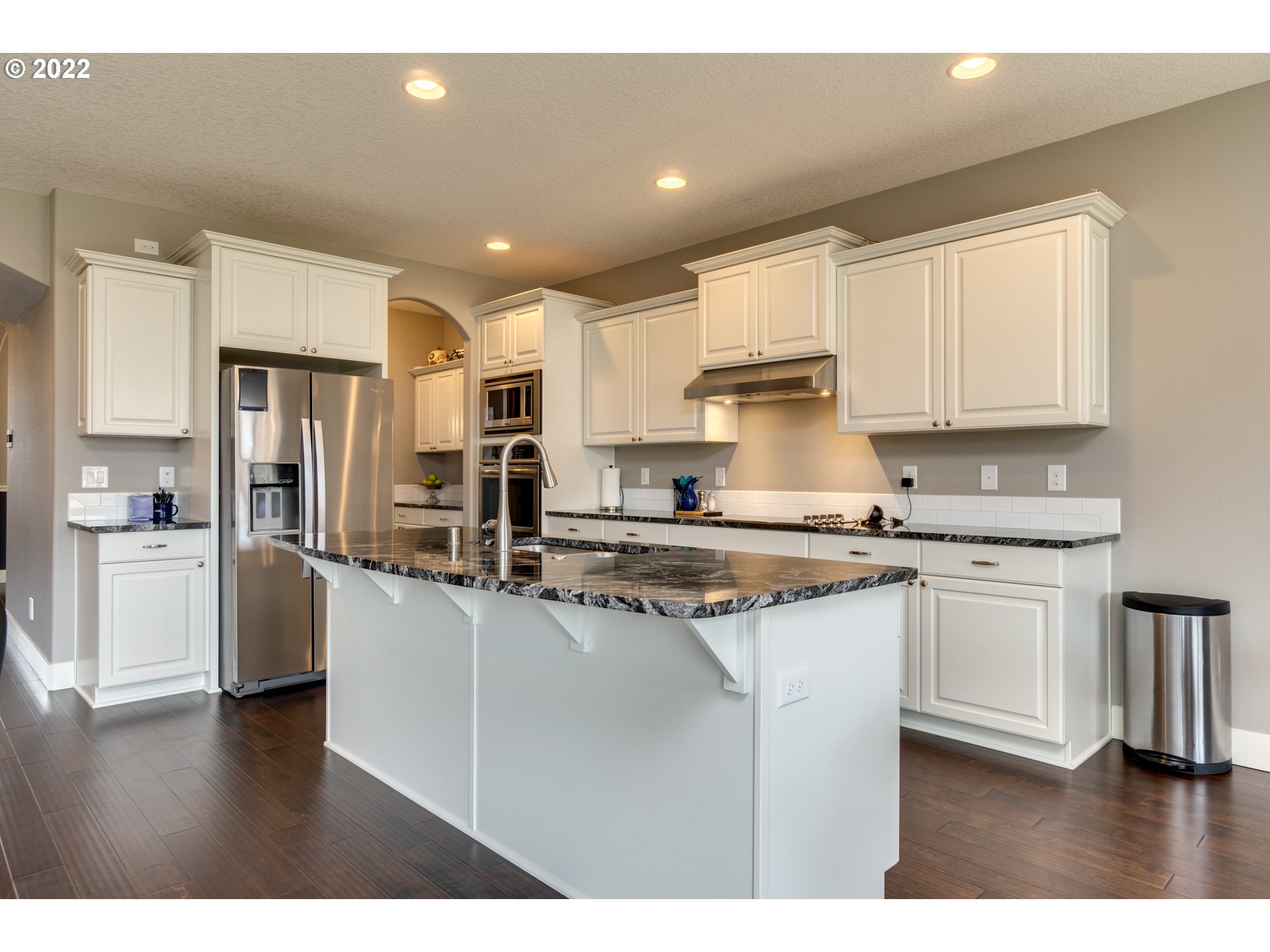 1626 South 46th Place Ridgefield, WA 98642 - Photo 2 of 32 a kitchen with stainless steel appliances granite countertop a refrigerator a sink dishwasher a stove and white cabinets with wooden floor