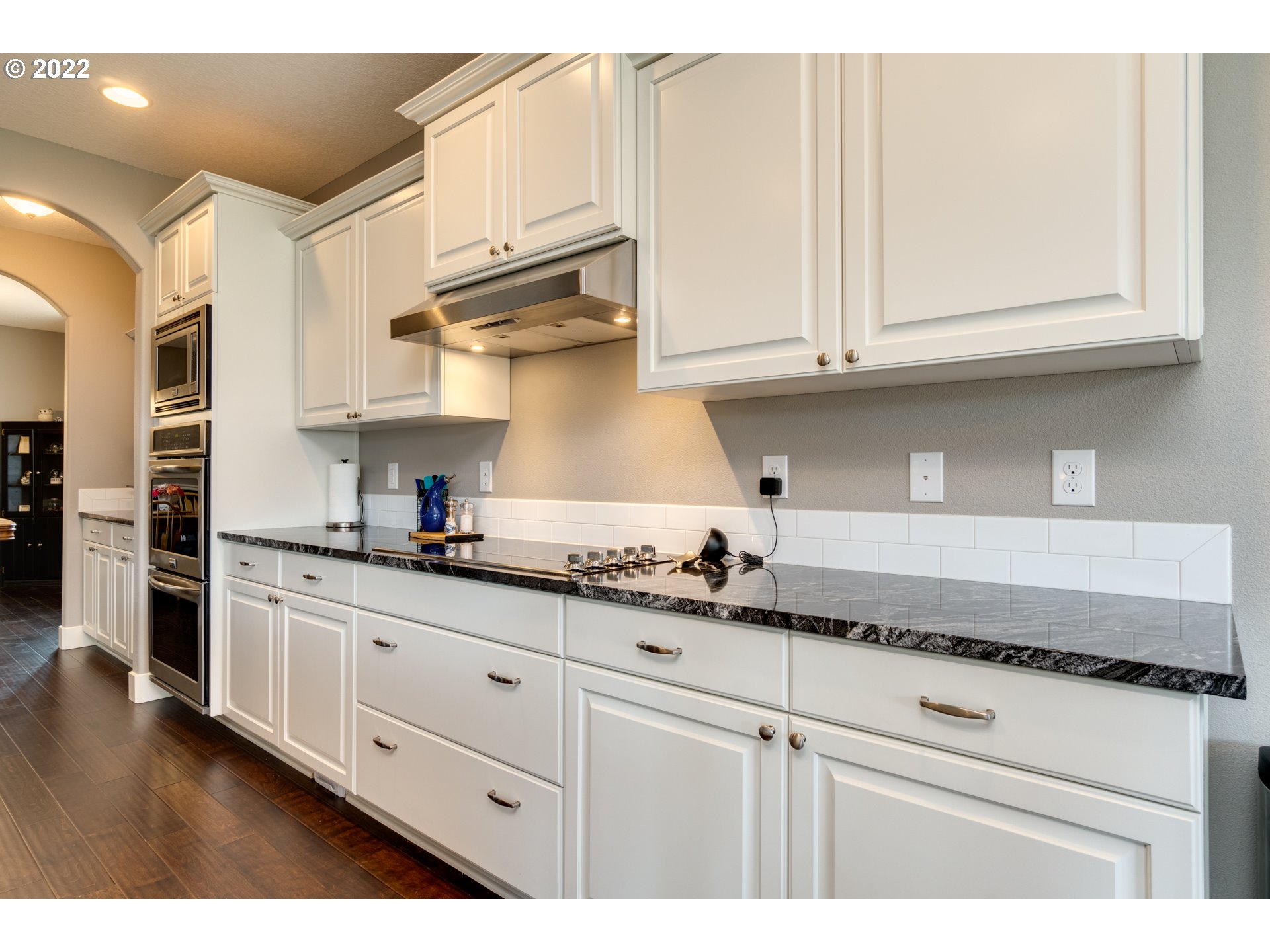 1626 South 46th Place Ridgefield, WA 98642 - Photo 8 of 32 a kitchen with granite countertop white cabinets and stainless steel appliances