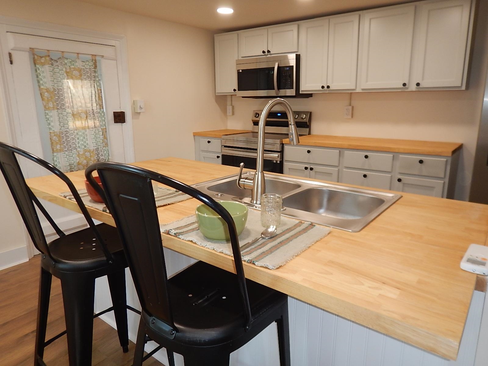 3653 Middlebrook Village Road Middlebrook, VA 24459 - Photo 16 of 48 a kitchen with stainless steel appliances kitchen island a table chair and cabinets
