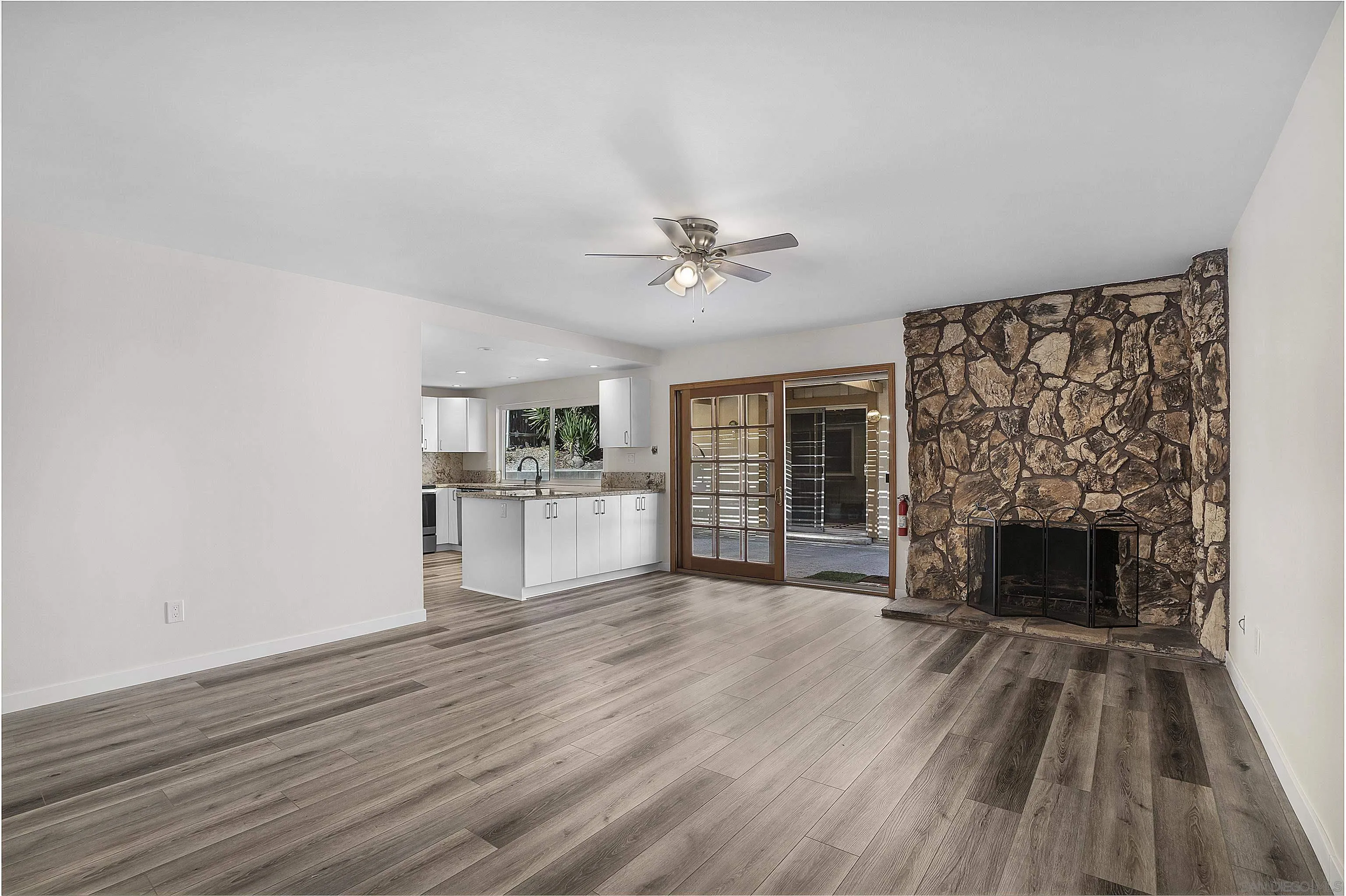 1454 Bathurst Place El Cajon, CA 92020 - Photo 13 of 35 a view of a livingroom with a fireplace a ceiling fan and wooden floor