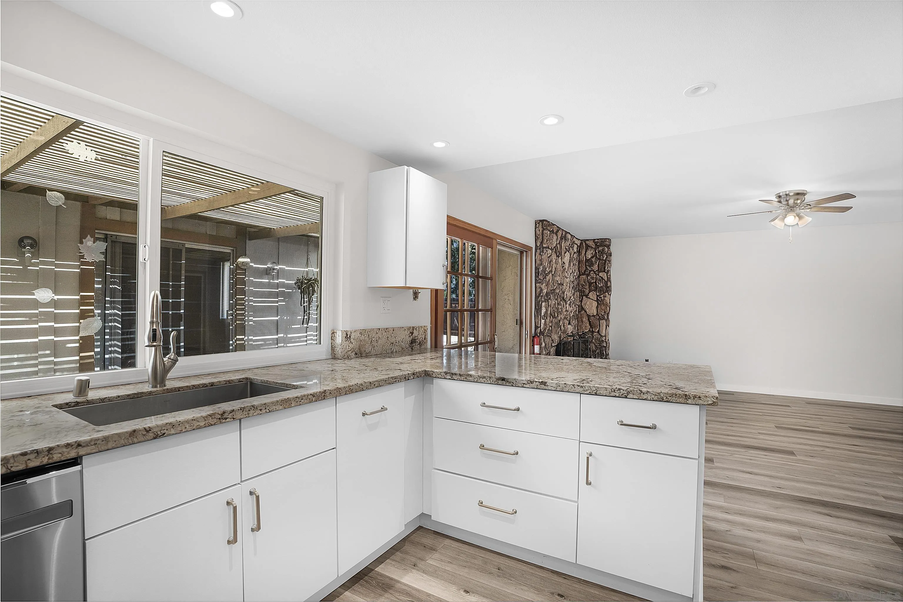 1454 Bathurst Place El Cajon, CA 92020 - Photo 15 of 35 a white kitchen with a sink and dishwasher with wooden floor