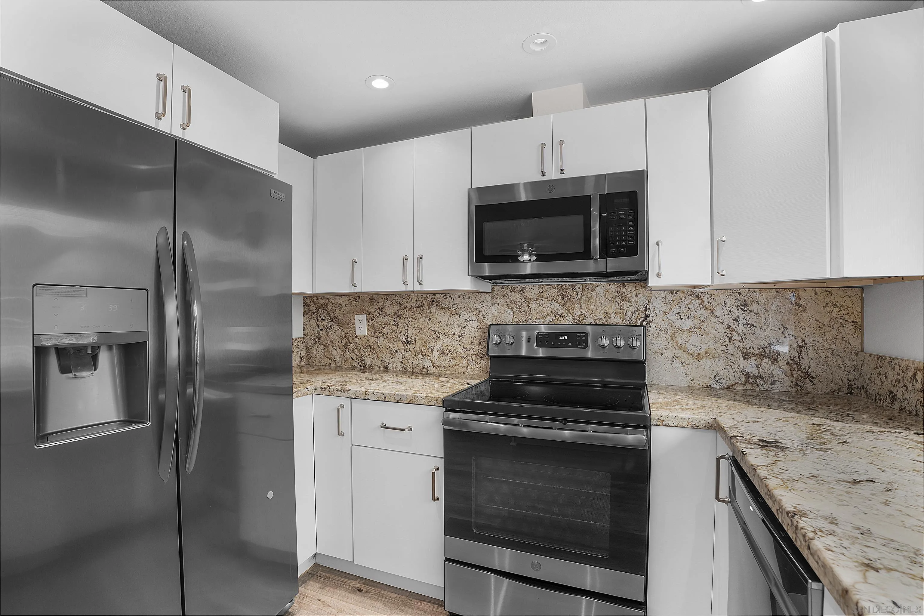 1454 Bathurst Place El Cajon, CA 92020 - Photo 16 of 35 a kitchen with granite countertop white cabinets stainless steel appliances and a sink