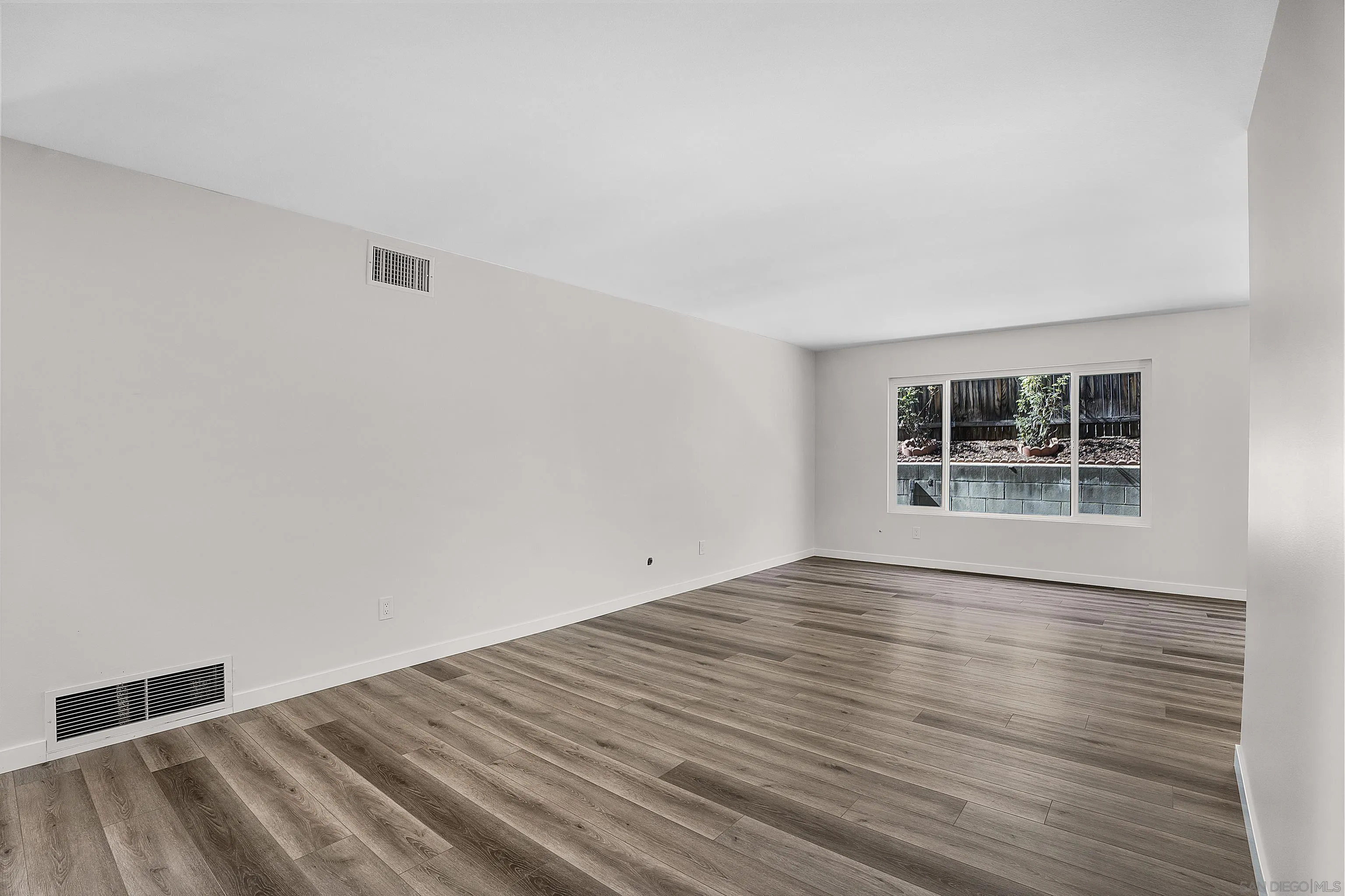1454 Bathurst Place El Cajon, CA 92020 - Photo 7 of 35 a view of an empty room with wooden floor and a window
