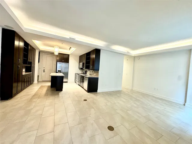 a view of kitchen with furniture and an empty room