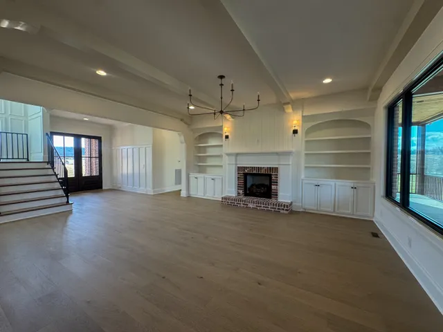 an empty room with fireplace and windows