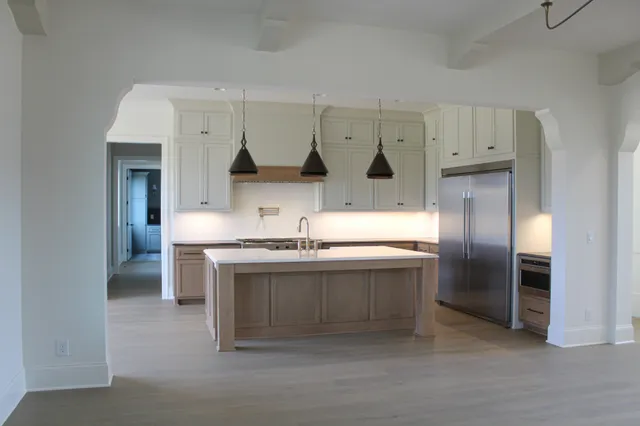 a kitchen with stainless steel appliances granite countertop a sink and a refrigerator