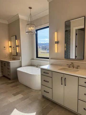 a bathroom with a double vanity sink large mirror and a bathtub