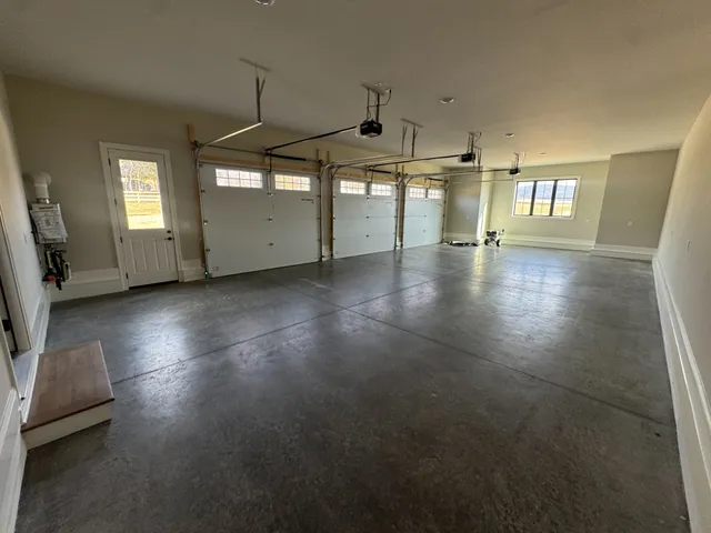 an empty room with windows and ceiling fan