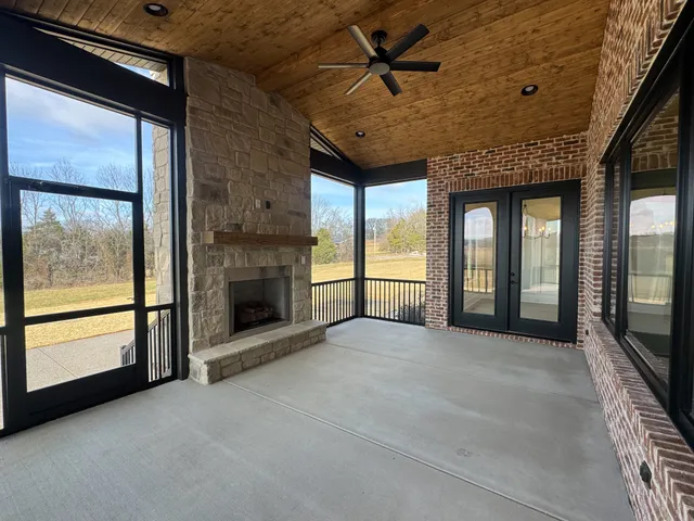 a view of an empty room with a fireplace and a window