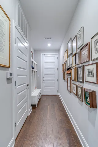 a view of hallway with stairs and wooden floor