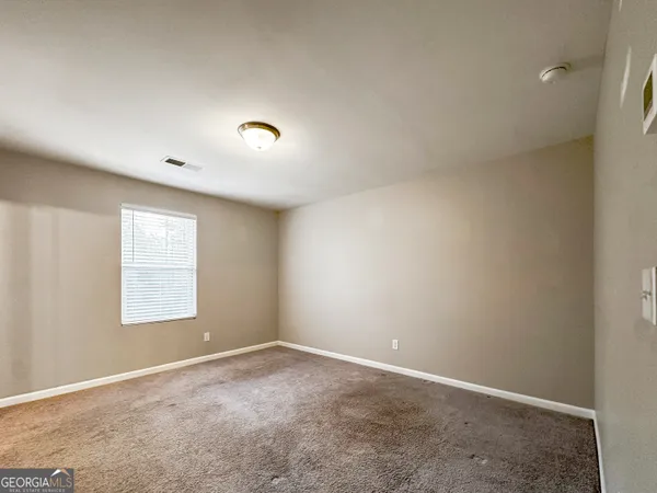 an empty room with a window and a ceiling fan view
