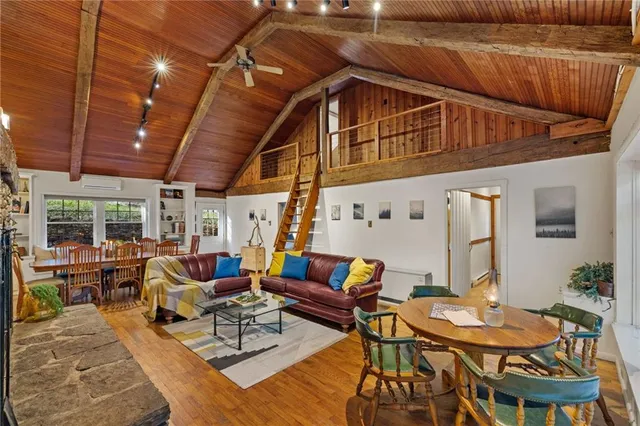 a view of a livingroom with furniture staircase and a floor to ceiling window