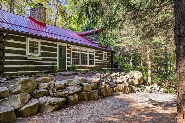 a view of a house with a large window and wooden fence
