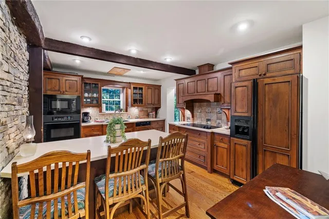 a kitchen with stainless steel appliances granite countertop a refrigerator and a stove top oven