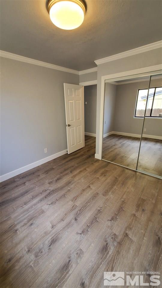 5880 Coyote Ridge Road Reno, NV 89523 - Photo 14 of 28 a view of an empty room with window and wooden floor