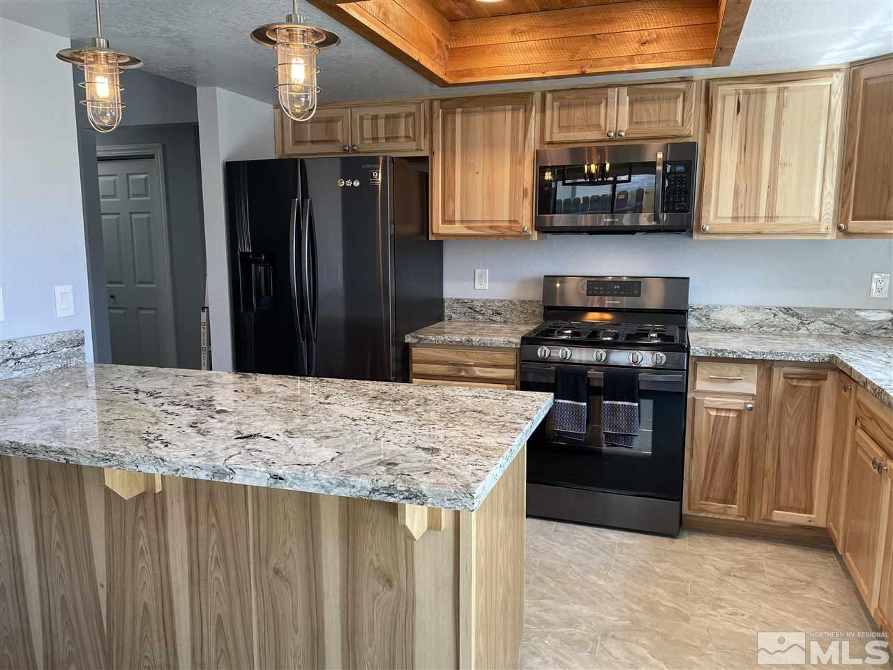 5880 Coyote Ridge Road Reno, NV 89523 - Photo 26 of 28 a kitchen with stainless steel appliances granite countertop a stove refrigerator and microwave