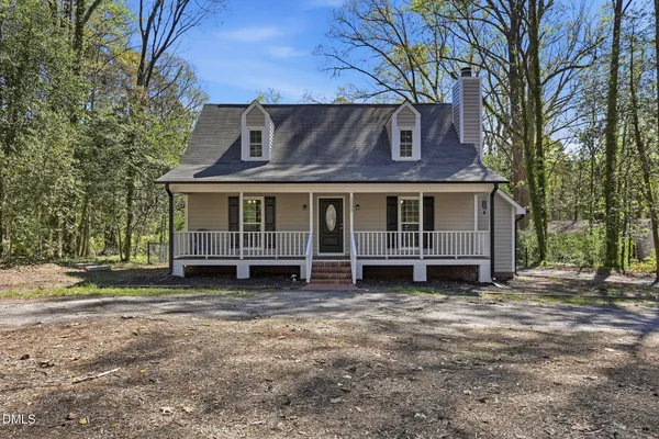 a view of a house with a yard and large tree