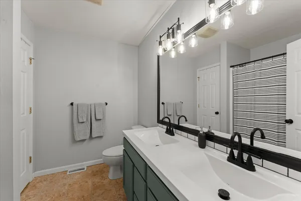 a bathroom with a sink double vanity and a toilet
