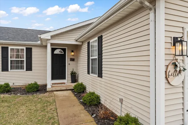 a view of a white house with a potted plant