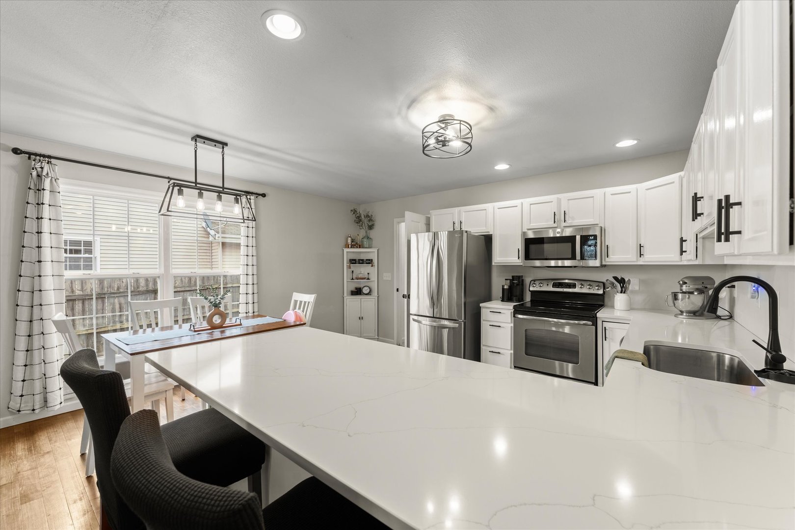 706 Northgate Drive St. Joseph, IL 61873 - Photo 10 of 33 a kitchen with stainless steel appliances a dining table chairs stove refrigerator and microwave