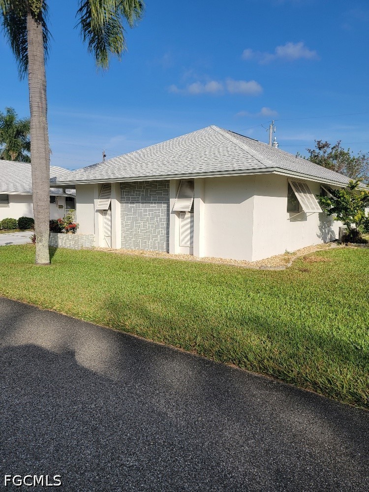 347 Richland Road Lehigh Acres, FL 33936 - Photo 1 of 16 a front view of a house with garden