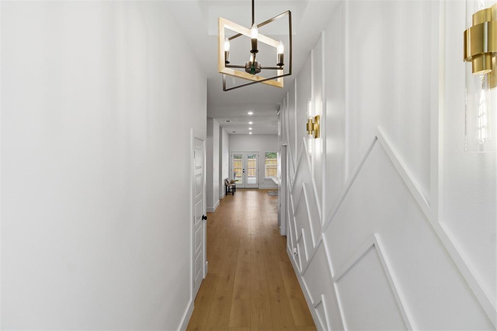 435 Waterboard Road Trinidad, TX 75163 - Photo 5 of 39 Long corridor featuring light wood-finish flooring, white walls, and a contemporary linear light fixture