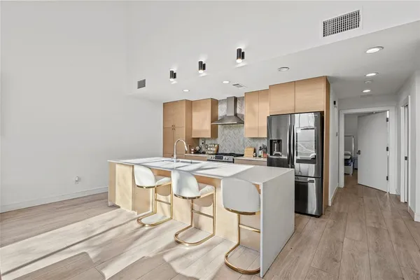 a kitchen with a refrigerator a stove cabinets and wooden floor