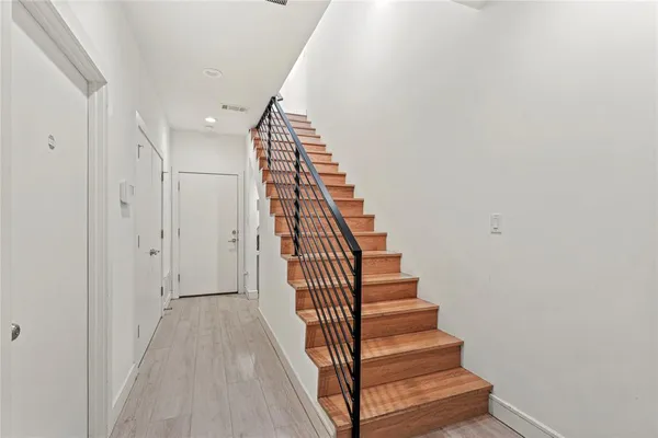 a view of a hallway with wooden floor and entryway