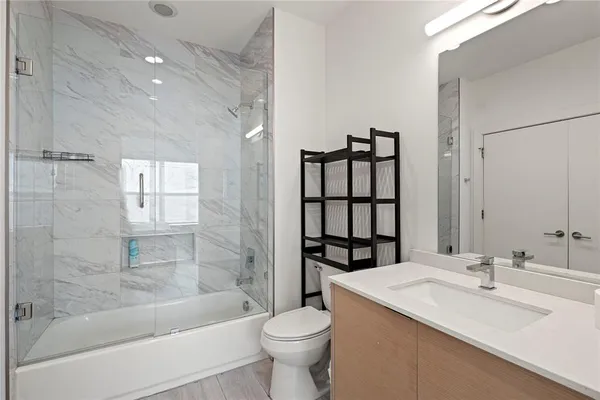 a bathroom with a sink a toilet and shower