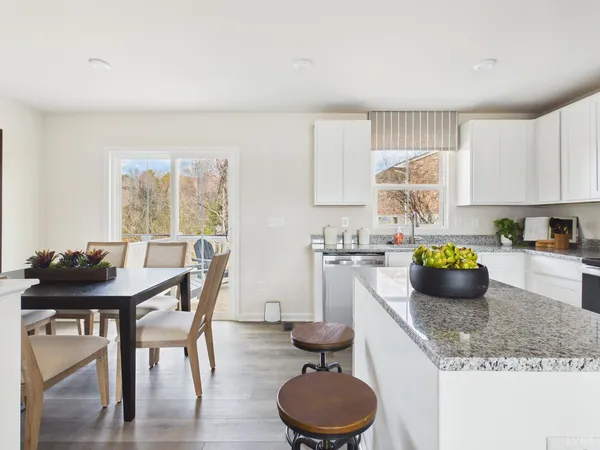 a kitchen with a granite countertop kitchen island a table and a sink