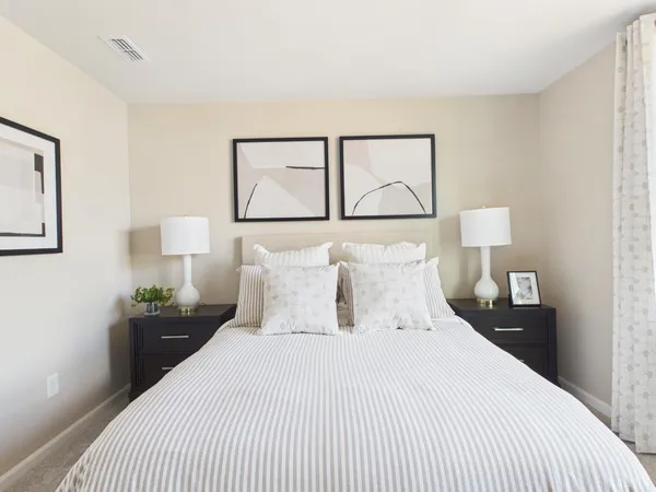 a bedroom with a bed and a painting on the wall