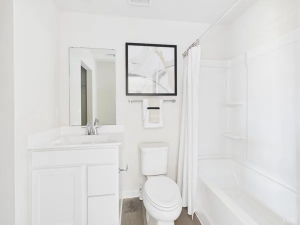 a bathroom with a toilet sink vanity tub and mirror