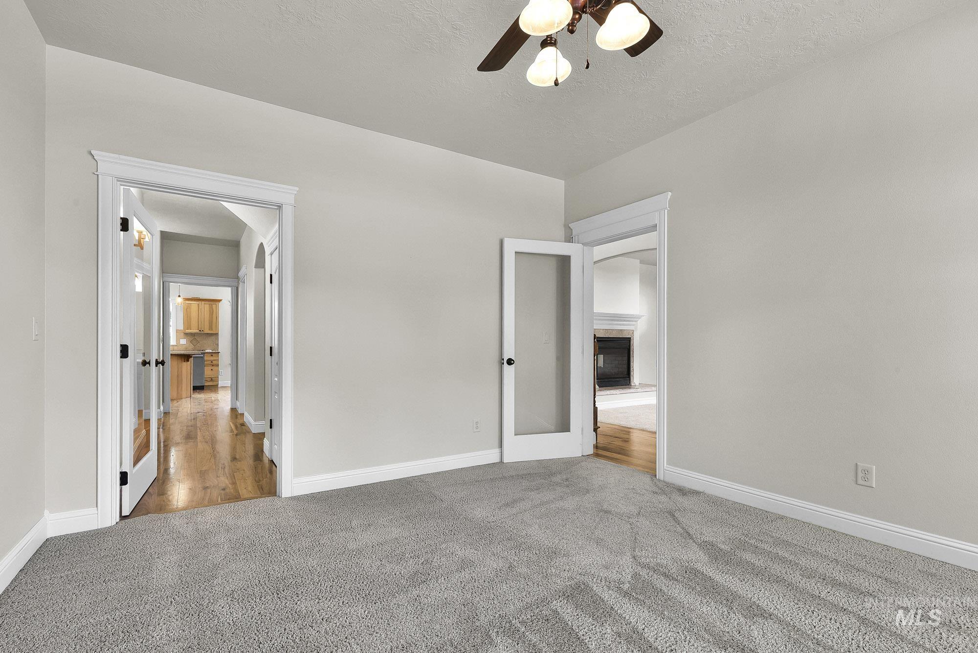 2172 West Cedar Grove Street Meridian, ID 83646 - Photo 6 of 49 Neutral gray carpeted room with light gray walls, white trim, and a ceiling fan with light fixture