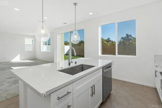 a kitchen with a sink a counter space and a refrigerator
