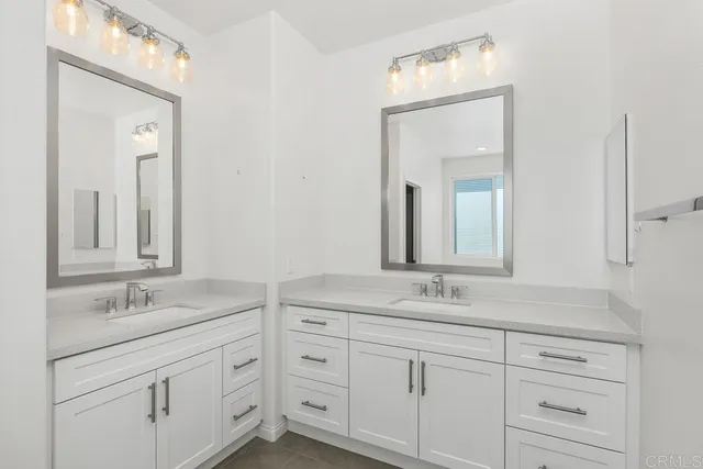 a bathroom with double sink and a mirror