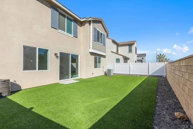 a view of an house with backyard and porch