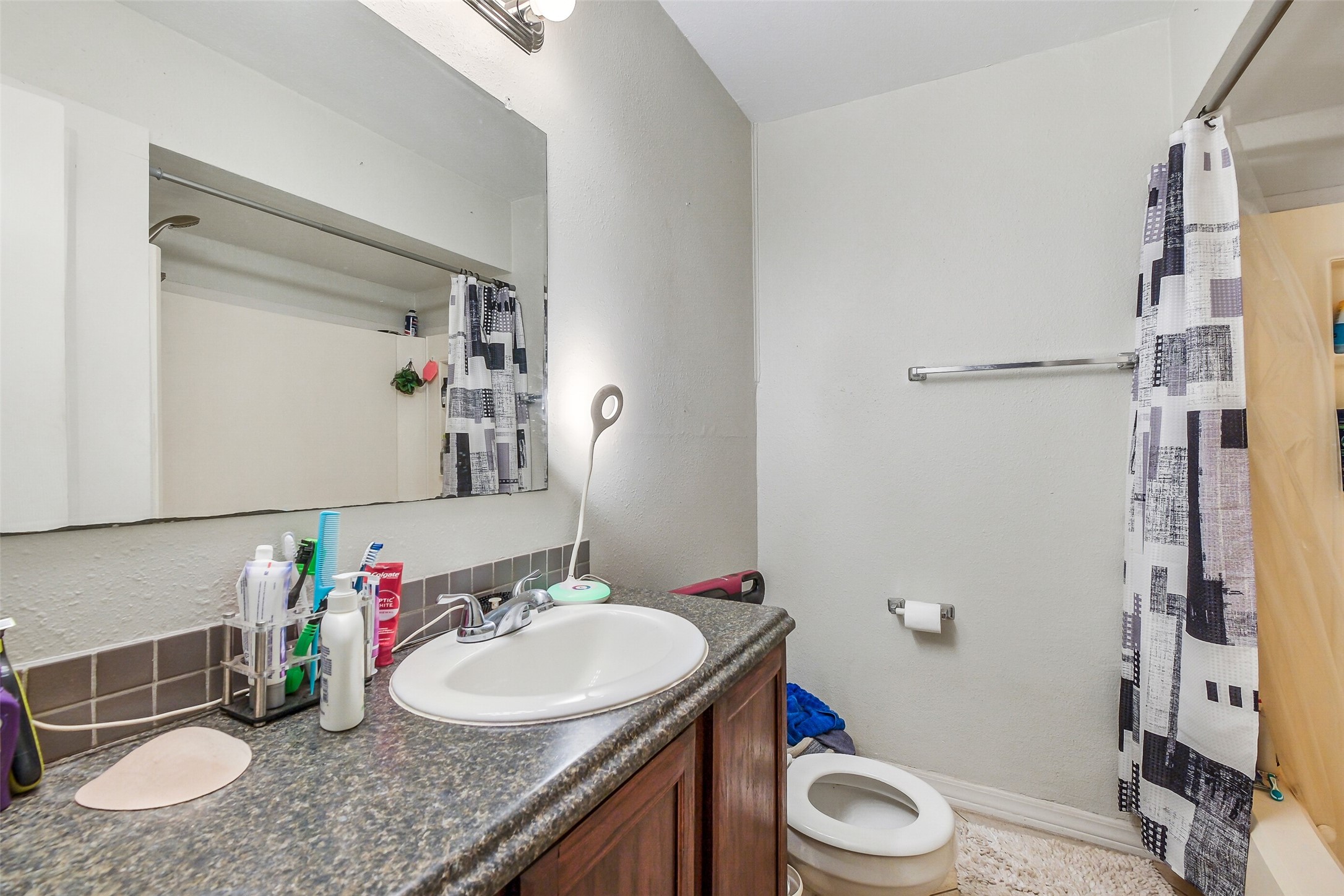 3435 Rosedale Street Houston, TX 77004 - Photo 18 of 34 a bathroom with a granite countertop sink toilet and shower
