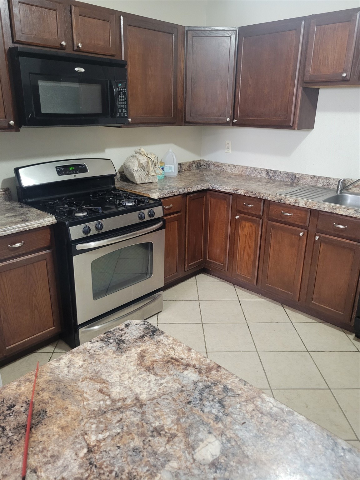 3435 Rosedale Street Houston, TX 77004 - Photo 34 of 34 a kitchen with granite countertop a stove a sink and a microwave