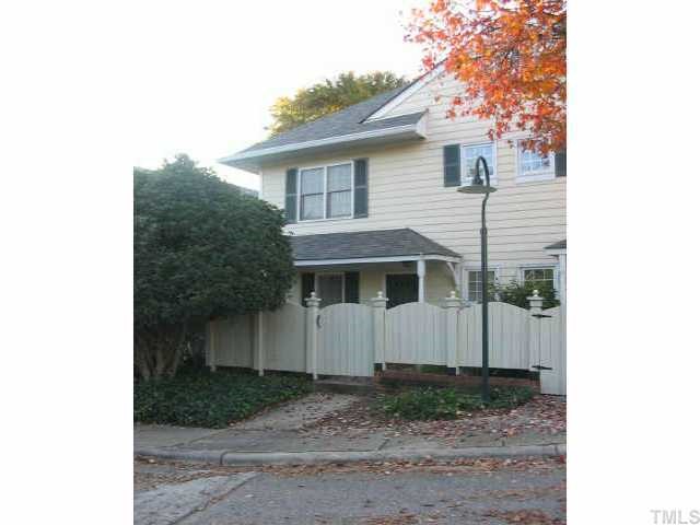 a view of a white house next to a yard
