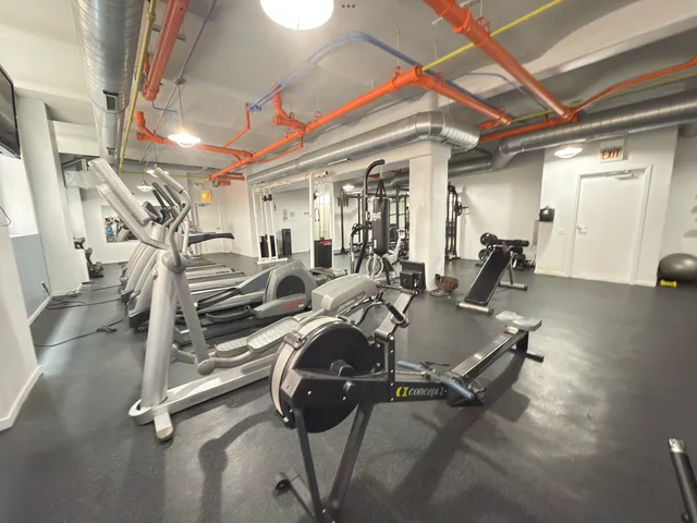 a living room with furniture gym equipment and a large window