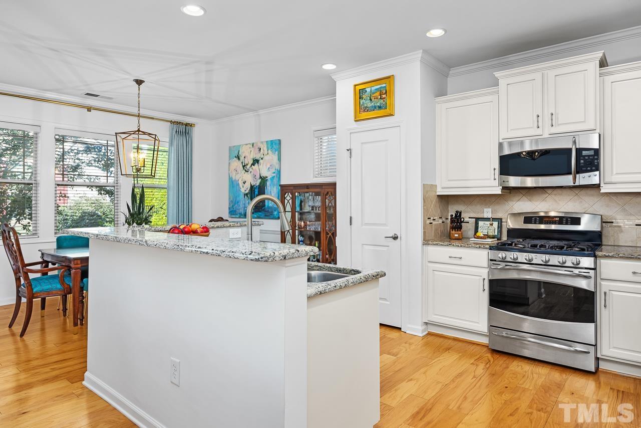5528 Wade Park Boulevard Raleigh, NC 27607 - Photo 12 of 30 a kitchen with stainless steel appliances granite countertop a stove a sink and a refrigerator