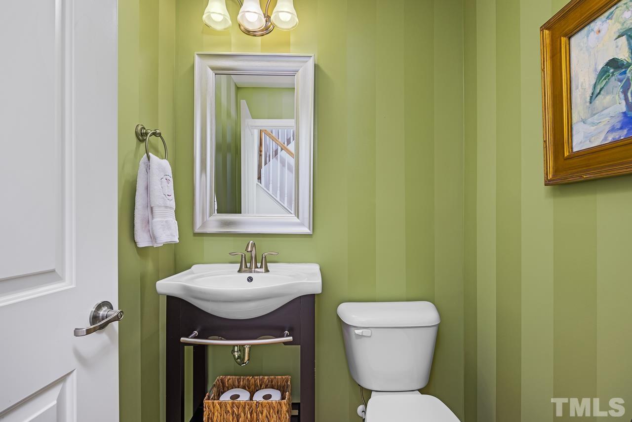 5528 Wade Park Boulevard Raleigh, NC 27607 - Photo 21 of 30 a bathroom with a toilet a sink and a mirror