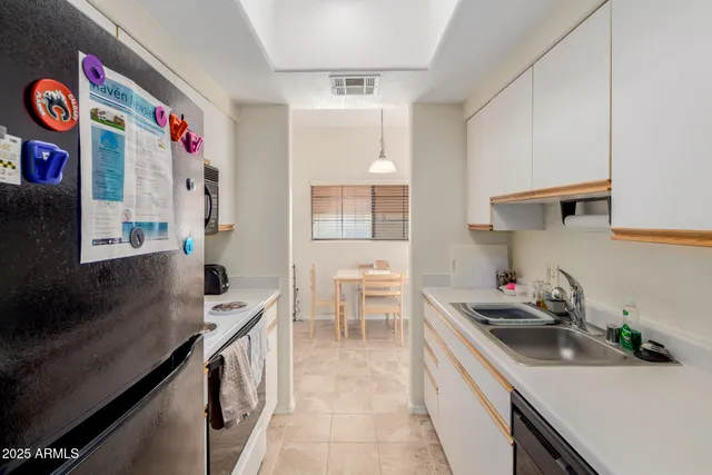 a kitchen with stainless steel appliances a sink dishwasher and a stove with wooden floor